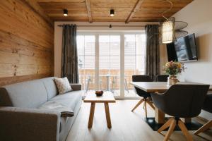 een woonkamer met een bank en een tafel bij SunApart by Apart4you in Haus im Ennstal