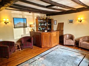 um quarto com um bar com cadeiras e uma mesa em Collaven Manor em Okehampton