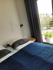 um quarto com uma cama azul e branca e uma janela em Rybacka em Augustów