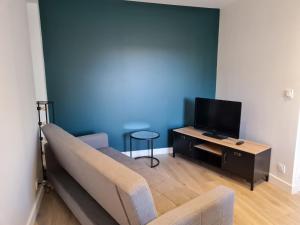 een woonkamer met een bank en een flatscreen-tv bij Ker Kiberen in Quiberon