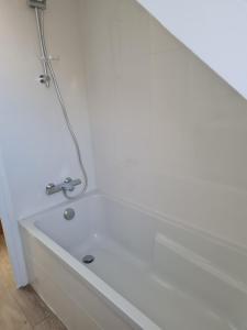 uma banheira branca com uma torneira na casa de banho em Ker Kiberen em Quiberon