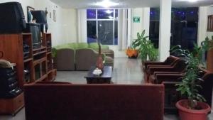 a living room with couches and a tv at Hotel Islas Galapagos in Puerto Baquerizo Moreno