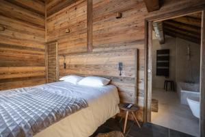 a bedroom with a bed and a bathroom with a tub at Chalets Choseaux Lézami in Saint-Sorlin-dʼArves