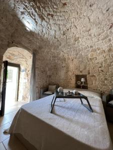 ein Schlafzimmer mit einem Bett und einer Steinmauer in der Unterkunft Il trullo di Mattia in Noci