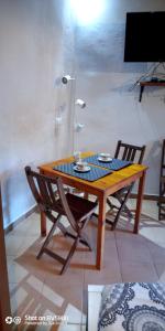 Casa Vittoria في كالكاتا: طاولة خشبية مع كرسيين وطاولة مع كوبين