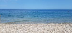 a person standing on a beach near the water at HMO Glamping & Suites in Vignanotica in Mattinata