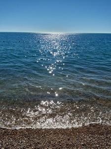 a body of water with the sun reflecting on the water at HMO Glamping & Suites in Vignanotica in Mattinata