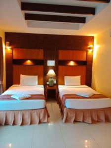 two beds in a hotel room with two lamps at Tommy Resort in Haad Rin