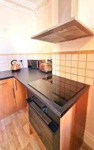 a kitchen with a black stove top oven at St Hilary Central Apartments in Llandudno