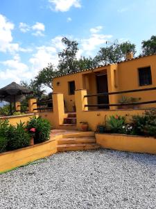 a yellow house with a staircase in front of it at Los Montes Traditional Casa with private pool in Viñuela