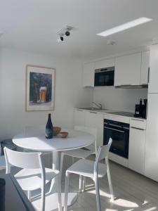 a white kitchen with a white table and chairs at L'atelier de Durbuy in Durbuy