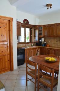 a kitchen with a table with a bowl of fruit on it at Villa skopelos in Skopelos Town