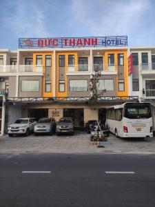 um grande edifício com carros estacionados em frente em ĐỨC THẠNH HOTEL em Rạch Giá