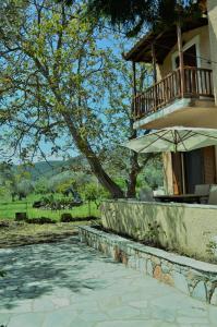 a house with an umbrella and a patio at Villa skopelos in Skopelos Town