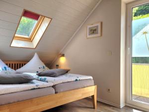 ein Schlafzimmer mit zwei Betten und einem Fenster in der Unterkunft Ahrtal Vier Sterne Ferienwohnungen Alexandra Weiler Panorama in Bad Neuenahr-Ahrweiler