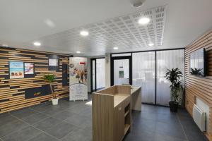an office with a reception desk and wooden walls at Résidence Néméa Caen Beaumois in Caen