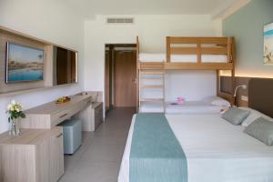 a bedroom with two bunk beds and a desk at Asterias Beach Hotel in Ayia Napa