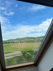 - une fenêtre dans une chambre avec vue sur un champ dans l'établissement Apartament Hemingwaya, à Jelenia Góra