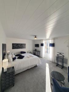 Dormitorio blanco con cama y mesa en Aux Lits du Canal, en Josselin