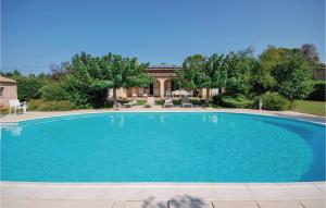 サレルヌにあるCozy Home In Salernes With Outdoor Swimming Poolの青い大型スイミングプール(椅子付)と家