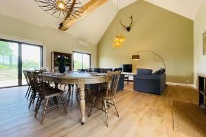 a dining room and living room with a table and chairs at La grange du Pigeonnier authenticity and gentleness 10 minutes from Tours in La Riche