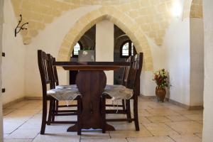 une table et des chaises dans une pièce avec une arche dans l'établissement Trulli Monte Madre, à San Vito dei Normanni