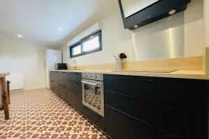 a kitchen with a sink and a stove at La grange du Pigeonnier authenticity and gentleness 10 minutes from Tours in La Riche