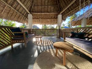 a living room with a couch and a table and chairs at Nakupenda paje villa in Paje