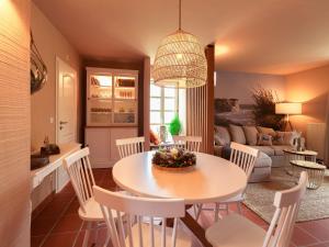 uma cozinha e sala de estar com mesa e cadeiras em Feriendorf Rugana - Komfortplus Appartement mit 2 Schlafzimmern und Terrasse A28 em Dranske
