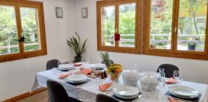 a dining room table with a white table cloth and chairs at Chalet Falcon With Hot Tub in Chamonix-Mont-Blanc
