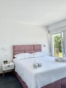 Un dormitorio blanco con una cama grande con toallas. en Elite rooms Split - FREE PARKING en Split