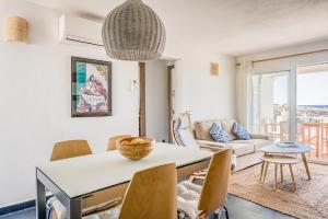 eine Küche und ein Wohnzimmer mit einem Tisch und Stühlen in der Unterkunft Binibeca Sunset in Sant Lluís
