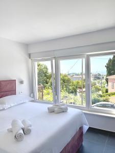 1 dormitorio con 1 cama blanca grande y ventanas en Elite rooms Split - FREE PARKING en Split