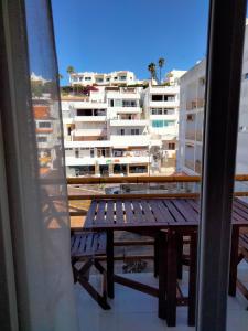 a bench on a balcony with a view of a building at Cerro Apartment in Carvoeiro