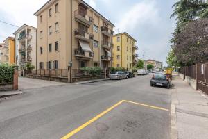 ulica z samochodami zaparkowanymi po stronie budynku w obiekcie Queen East Verona Appartamenti w Weronie