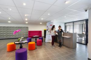two women standing at a counter in an office at Résidence Néméa Aix Campus 1 in Aix-en-Provence