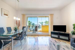 a living room with a dining table and a television at Modern Apartment in Jardin Botanico in La Cala de Mijas