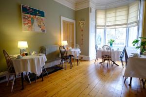 a dining room with two tables and chairs and a window at Kingsway Guest House in Edinburgh