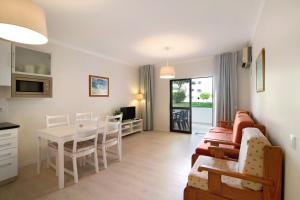 ein Wohnzimmer mit Sofa und Tisch in der Unterkunft Apartamento Jardins da Falésia in Albufeira