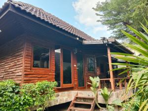 a wooden house with a staircase in front of it at Tommy Resort in Haad Rin