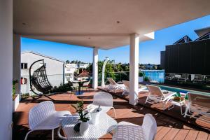 a patio with white chairs and a swimming pool at Dedaj Resort - Villa Auri in Zadar