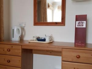 uma mesa de madeira com um espelho em cima em A35 Pit Stop Rooms em Axminster