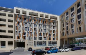 a large building with cars parked in a parking lot at Résidence Nemea Aix Campus 2 in Aix-en-Provence