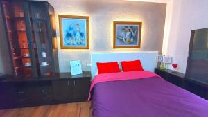 a bedroom with a purple bed with two red pillows at PRINCIPADO A in Puerto de la Cruz