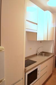 a small kitchen with white cabinets and a sink at PRINCIPADO A in Puerto de la Cruz