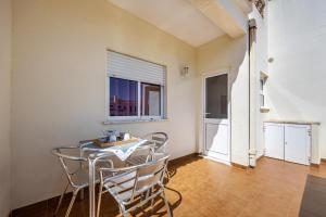 een eetkamer met een tafel en stoelen en een raam bij Villas Brites nº4 in Burgau