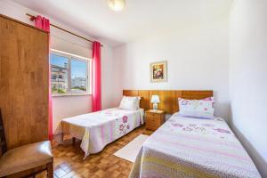 een slaapkamer met twee bedden en een raam bij Villas Brites nº4 in Burgau +23 foto's