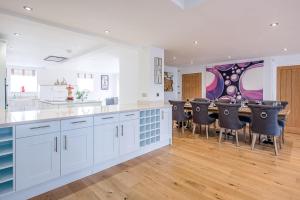 a kitchen with white cabinets and a bar with black chairs at Guild House, Aldeburgh in Aldeburgh +40 photos