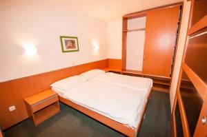 Habitación pequeña con cama y armario en Hotel Agava, en Božava