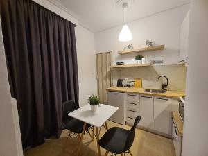 een kleine keuken met een witte tafel en stoelen bij Apartment in the heart of the city 5A in Larisa